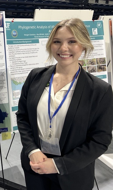 Aryn O'Dell stands by a poster.